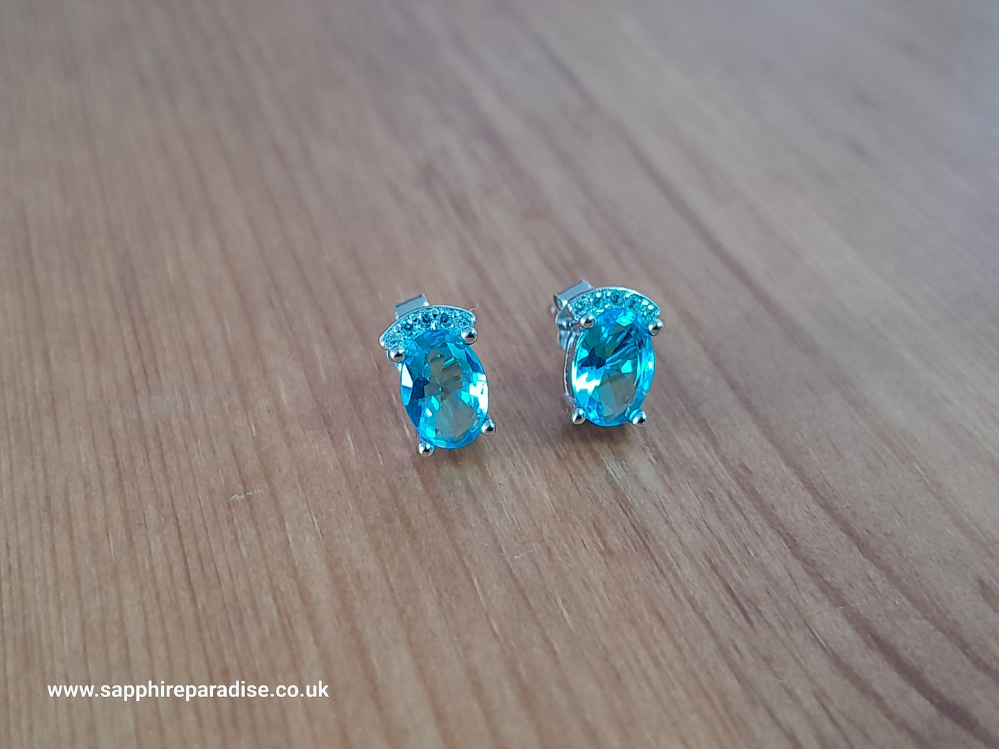 Stylish stud earrings feature a combination of sparkling clear and Swiss Blue Topaz cubic zirconia stones, everyday wear & special occasions