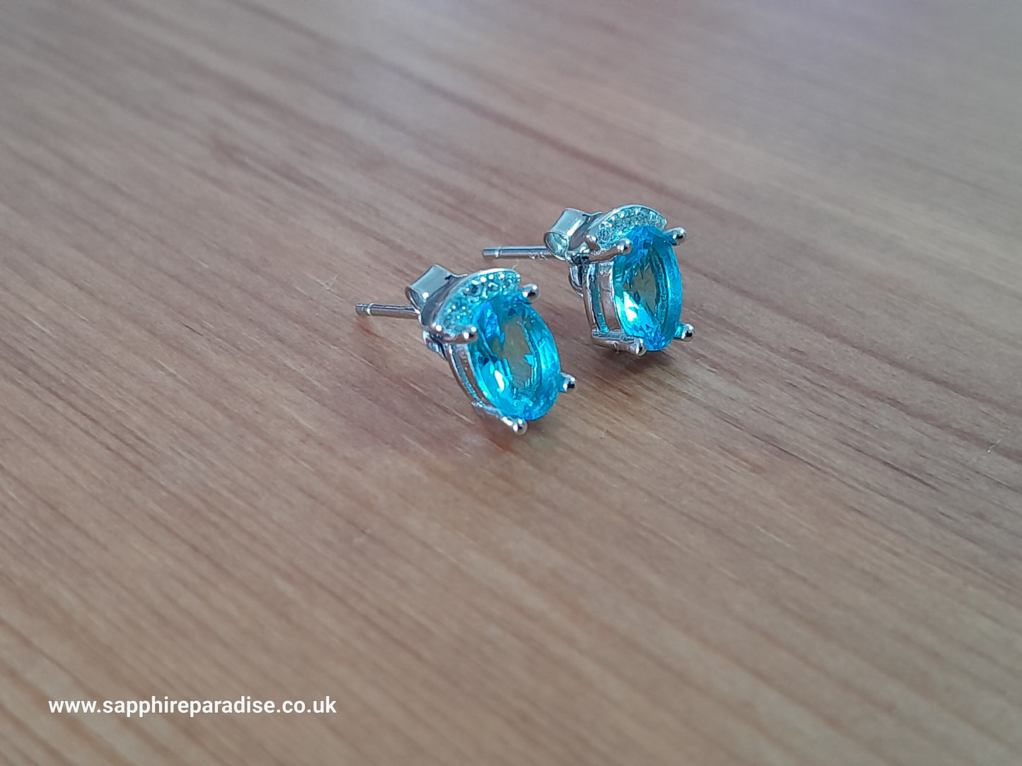 Stylish stud earrings feature a combination of sparkling clear and Swiss Blue Topaz cubic zirconia stones, everyday wear & special occasions