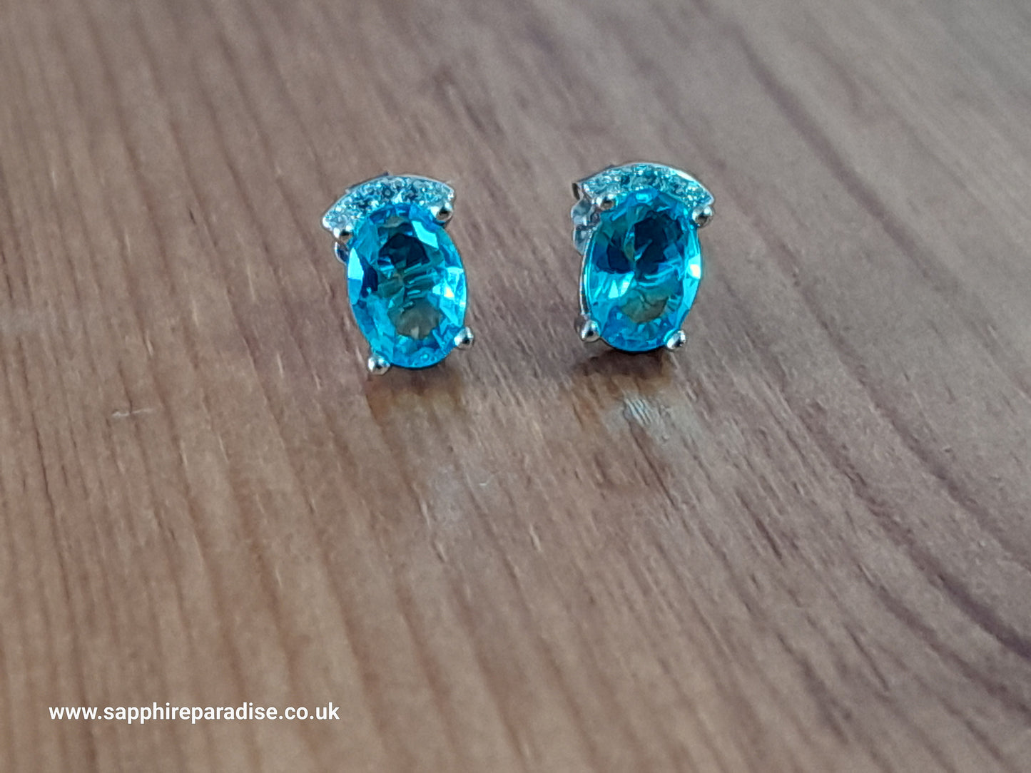 Stylish stud earrings feature a combination of sparkling clear and Swiss Blue Topaz cubic zirconia stones, everyday wear & special occasions