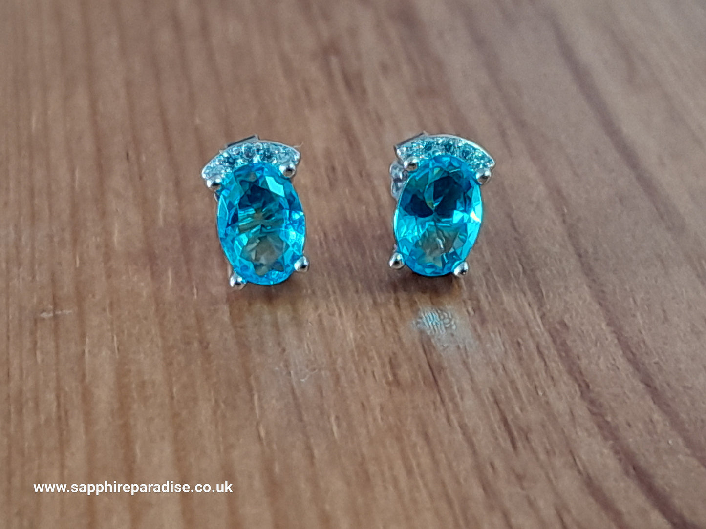 Stylish stud earrings feature a combination of sparkling clear and Swiss Blue Topaz cubic zirconia stones, everyday wear & special occasions