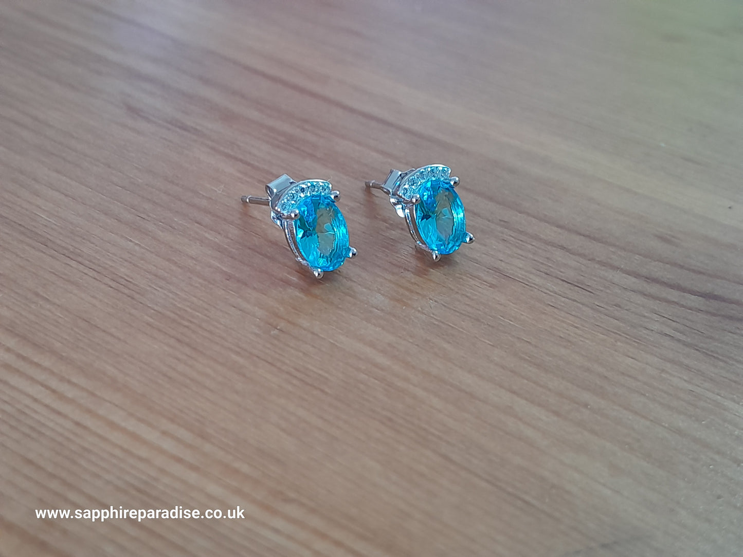 Stylish stud earrings feature a combination of sparkling clear and Swiss Blue Topaz cubic zirconia stones, everyday wear & special occasions