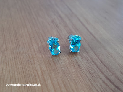 Stylish stud earrings feature a combination of sparkling clear and Swiss Blue Topaz cubic zirconia stones, everyday wear & special occasions
