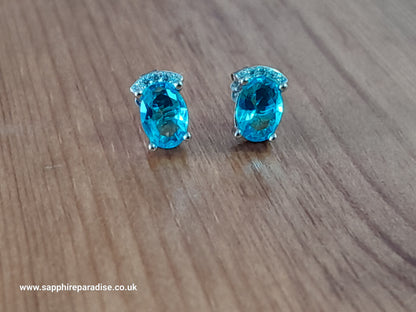 Stylish stud earrings feature a combination of sparkling clear and Swiss Blue Topaz cubic zirconia stones, everyday wear & special occasions