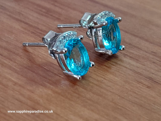 Stylish stud earrings feature a combination of sparkling clear and Swiss Blue Topaz cubic zirconia stones, everyday wear & special occasions