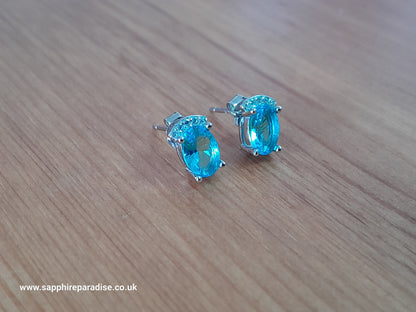 Stylish stud earrings feature a combination of sparkling clear and Swiss Blue Topaz cubic zirconia stones, everyday wear & special occasions